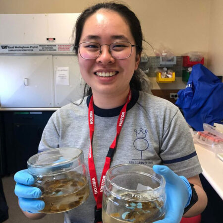 Yun Yi Ok holding giant kelp blades in jars